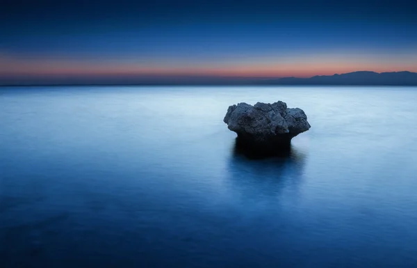 Одинокая скала в море — стоковое фото