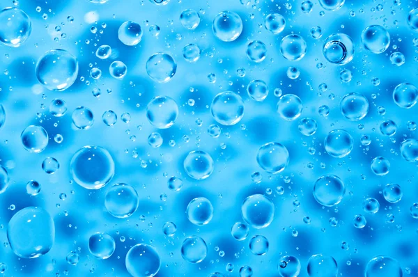 Achtergrond van blauw water grote en kleine druppels — Stockfoto