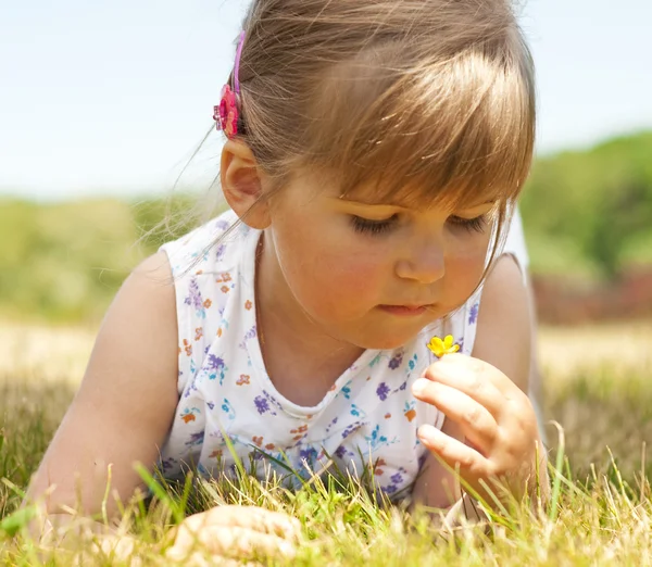 Little girl lying on grass in the park — Stock Photo, Image