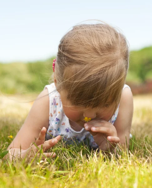 Little girl lying on grass in the park — Stock Photo, Image