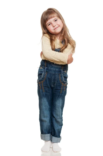 Drăguță fetiță purtând blugi în general pozând în studio și smil — Fotografie, imagine de stoc