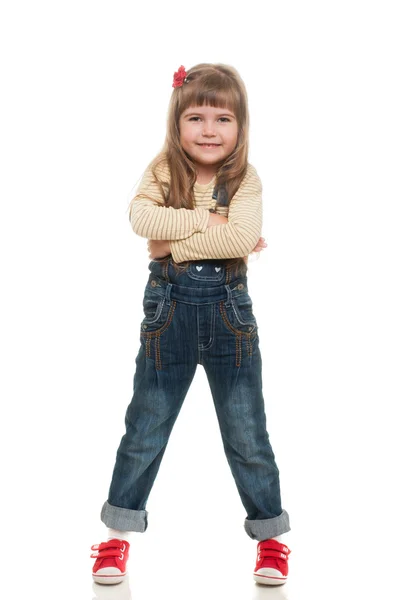 Cute little girl wearing jeans overall posing in studio and smil — Stock Photo, Image