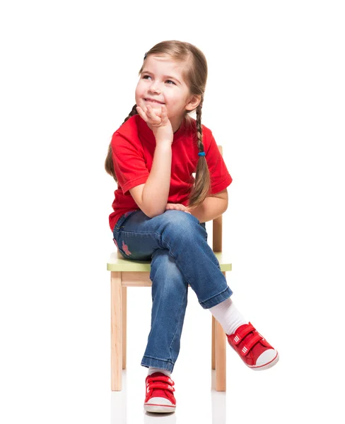 Lilla flickan bär röda t-kort och poserar på stol — Stockfoto