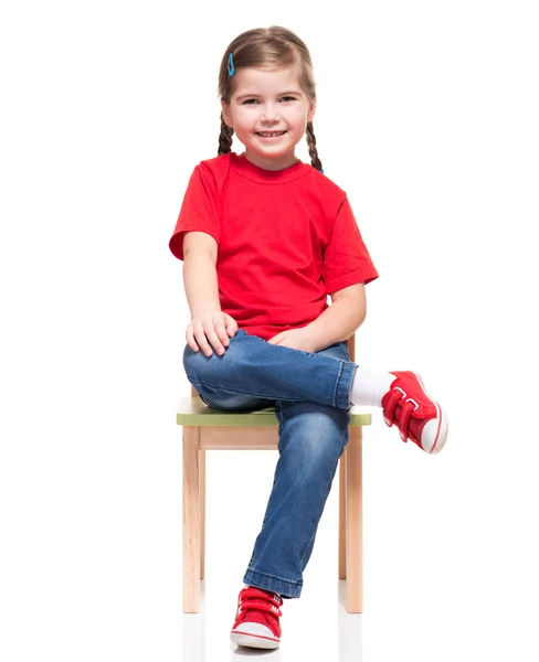 Niña usando t-short rojo y posando en silla — Stok fotoğraf