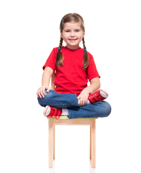 Fetiță purtând roșu t-scurt și pozând pe scaun — Fotografie, imagine de stoc