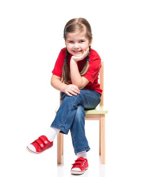 Menina vestindo vermelho t-curto e posando na cadeira — Fotografia de Stock