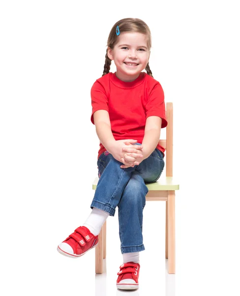 Little girl wearing red t-short and posing on chair — Stock Photo, Image