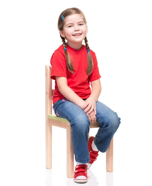 Kleines Mädchen trägt rotes T-Shirt und posiert auf Stuhl — Stockfoto