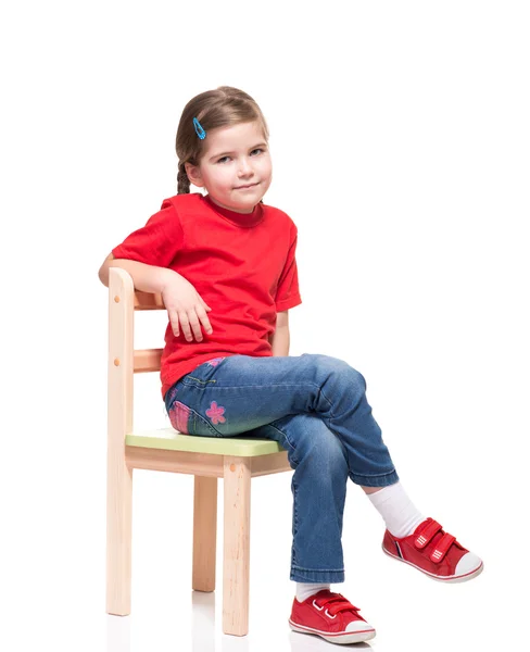 Little girl wearing red t-short and posing on chair — Stock Photo, Image