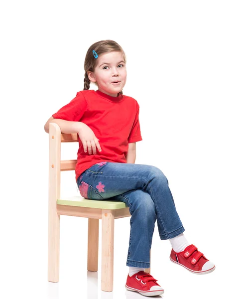 Petite fille portant t-short rouge et posant sur la chaise — Photo