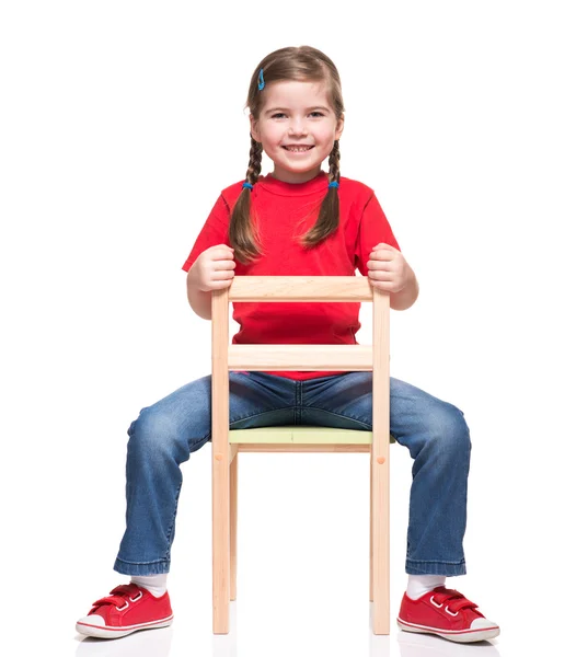 Niña usando t-short rojo y posando en silla — Stok fotoğraf