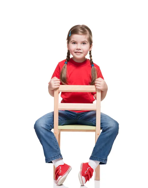 Niña usando t-short rojo y posando en silla — Stok fotoğraf