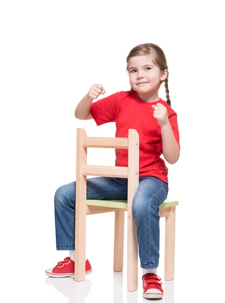 Little girl wearing red t-short and posing on chair — Stock Photo, Image