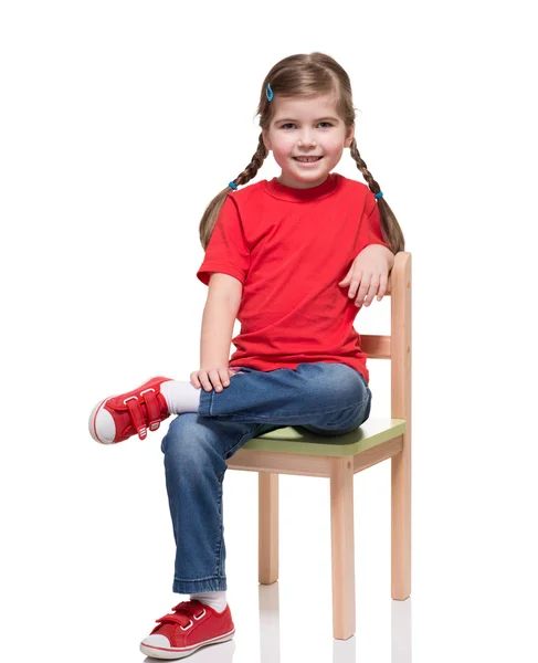 身穿红色 t 短和摆在椅子上的小女孩 — 图库照片