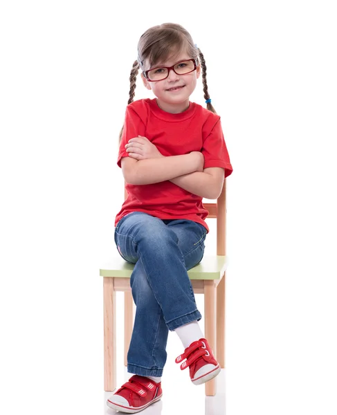 Little girl wearing red t-shirt and posing on chair — Stock Photo, Image