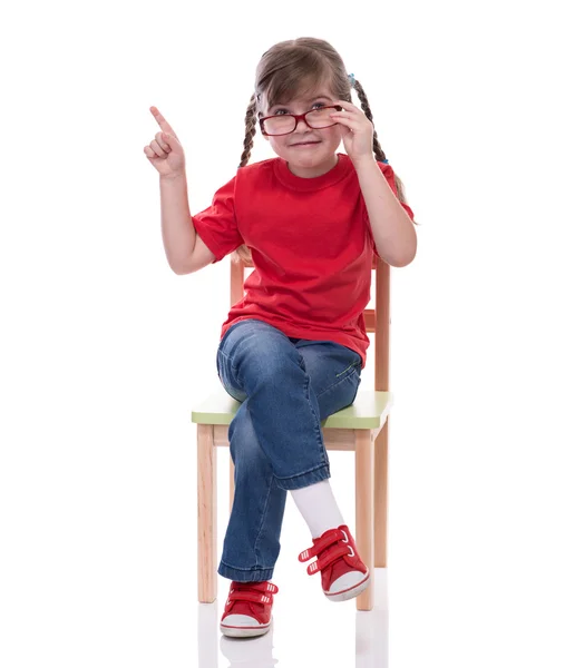 Niña vistiendo camiseta roja y vidrio apuntando a algún lugar — Foto de Stock