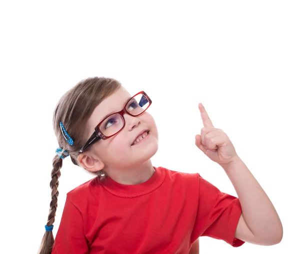 Little girl wearing glasses and pointing by forefinger to somewh — Stock Photo, Image