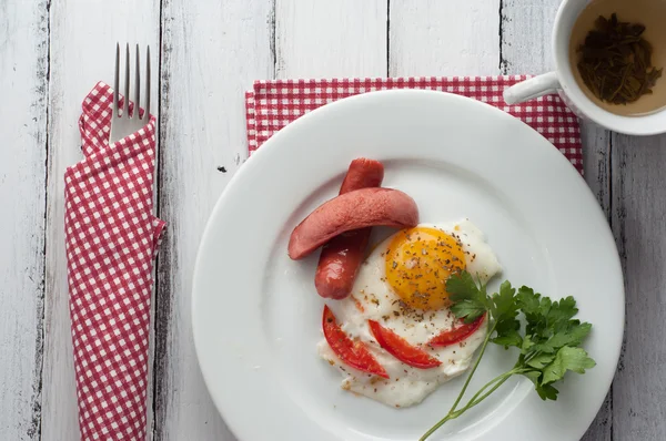 Омлет на тарелке с кусочками помидоров и колбасы — стоковое фото