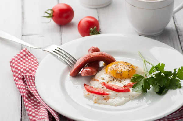 Омлет на тарелке с кусочками помидоров и колбасы Стоковое Фото