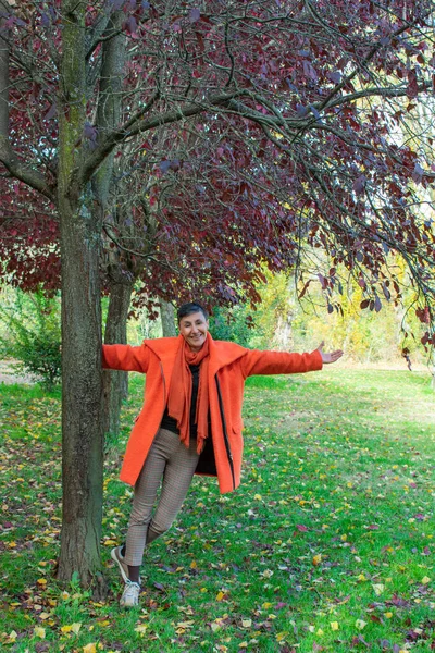 Woman Orange Coat Open Arms Tree — стоковое фото
