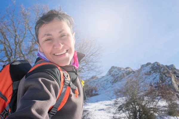 在白雪覆盖的山上 一个微笑的女远足者的画像 — 图库照片