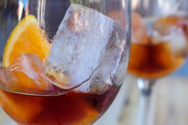 Meyankökü buzlu ve arkaplanı bulanık meyve dilimli bir bardak.