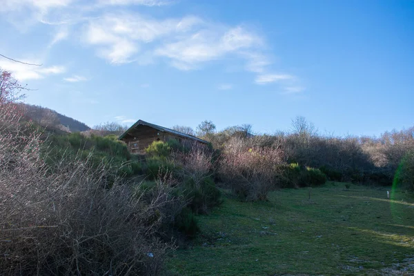 在群山中间的一个有蓝天的小木屋 — 图库照片