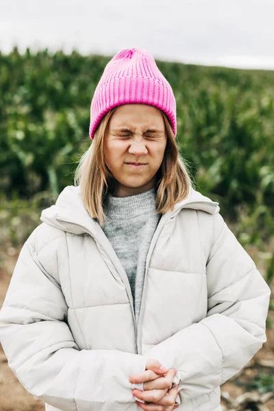 Retrato com olhos fechados de uma adolescente engraçada e fofa em um fundo de um campo verde com milho — Fotografia de Stock