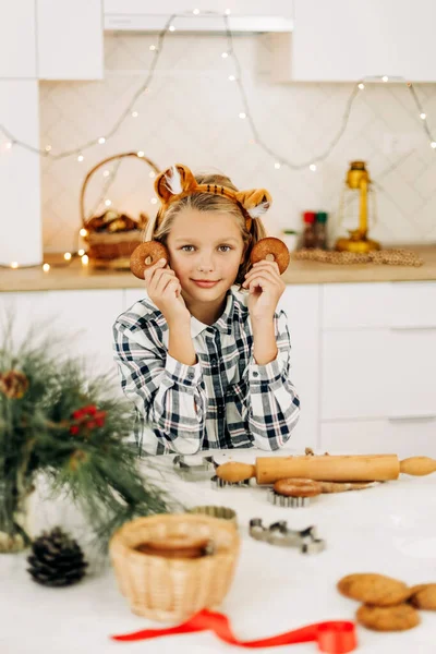 Retrato de una chica alegre sosteniendo una galleta decorativa de Navidad en su mano. Preparación para las fiestas, espíritu navideño, golosinas navideñas — Foto de Stock