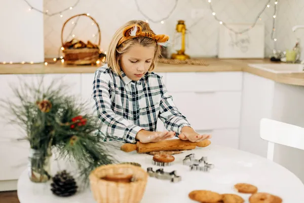 A cute girl in tiger ears is baking cookies for Christmas or New Year. Symbol of the year, family tradition, Christmas treat — Stock Photo, Image