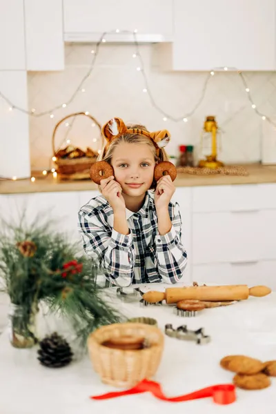 Portrait of a joyful girl holding a Christmas decorative cookie in her hand. Preparation for the holidays, Christmas spirit, Christmas treats — Stock Photo, Image