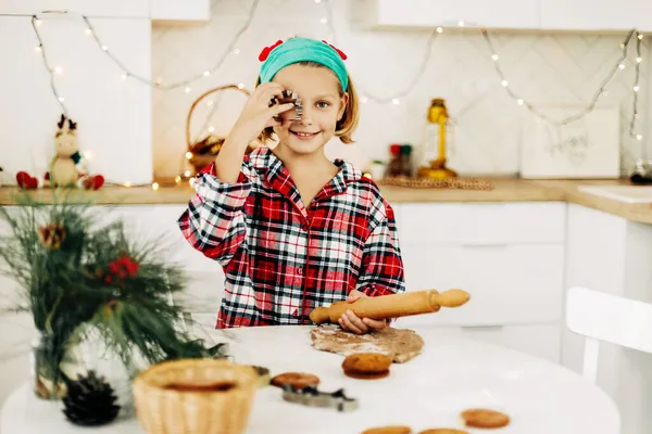 성탄절 이브나 새해 전날에 격자무늬 셔츠를 입은 여학생 이 크리스마스 쿠키를 굽고 있다. — 스톡 사진