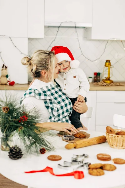 A mother and her little son are preparing Christmas cookies. Happy family in the kitchen. Preparation for the holiday, Christmas mood, family traditions — Stock Photo, Image