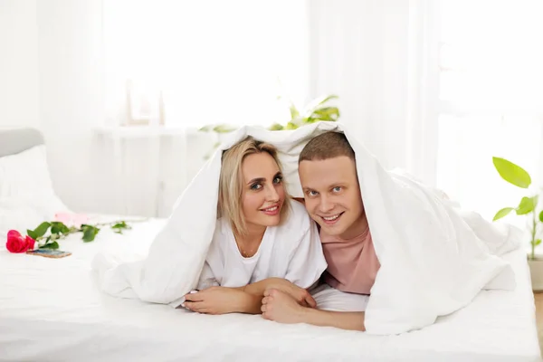 Влюбленная пара, лежащая под одеялом, проводящая вместе выходные, медовый месяц — стоковое фото