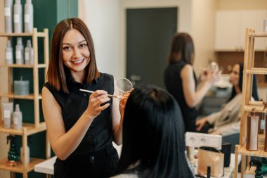Makyöz kuaföründe çalışıyor, profesyonel makyaj yapıyor. Güzellik endüstrisi, makyaj, dönüşüm