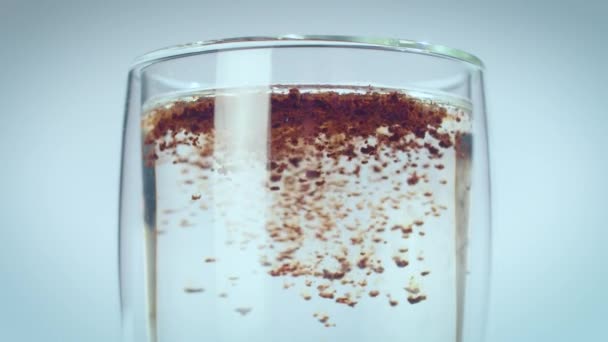 Cafeaua instant se toarnă într-un pahar cu apă caldă. Sticlă cu pereţi dubli. mișcare lentă . — Videoclip de stoc