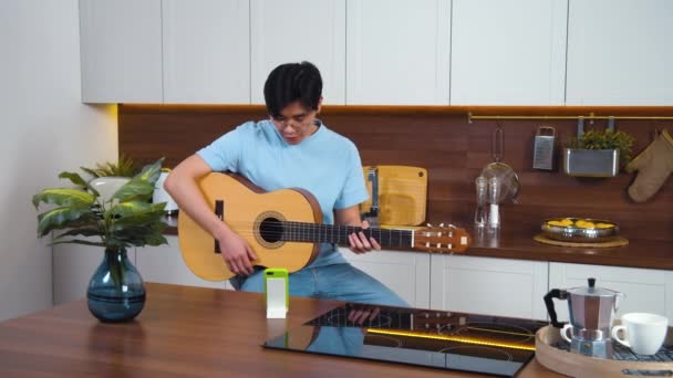 Sonriente Asiático Joven Estudio Tocar Guitarra Por Videollamada Con Profesor — Vídeo de stock