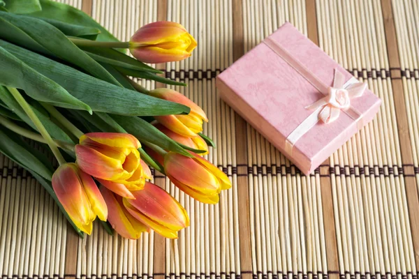 Boeket van tulpen en roze geschenkdoos — Stockfoto