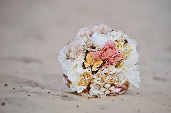 Bouquet, un bouquet de mariage de fleurs couché sur le sable de la plage solaire — Photo