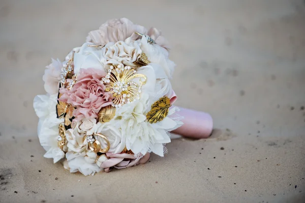 Bouquet, un bouquet de mariage de fleurs couché sur le sable de la plage solaire — Photo
