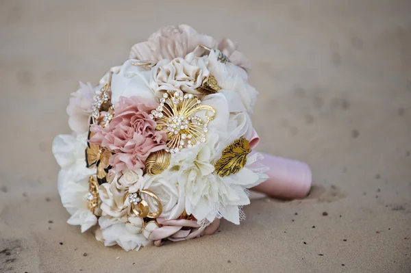 Bukett, en bukett blommor bröllop liggande på sanden på stranden solar Stockbild