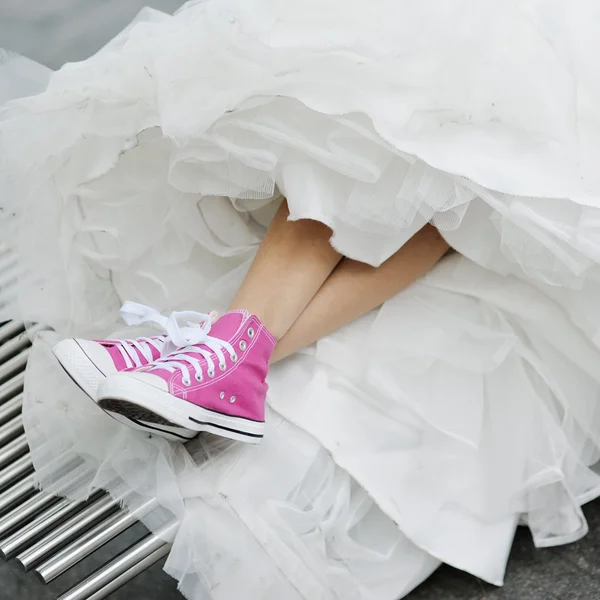 Pink gym shoes and a wedding dress Royalty Free Stock Photos