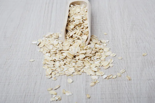 Oatmeal flakes scattered on a light background — Stock Photo, Image