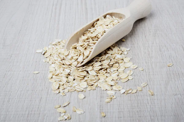 Oatmeal flakes scattered on a light background — Stock Photo, Image