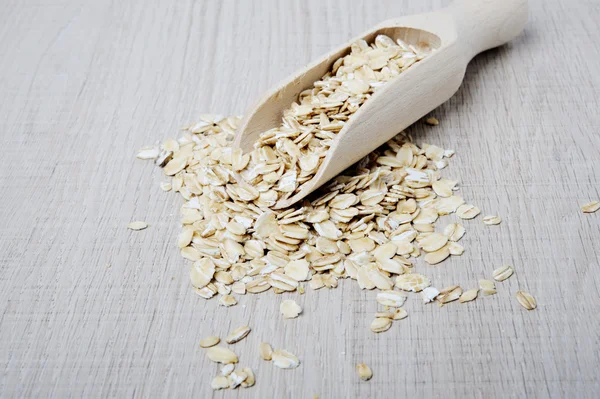 Oatmeal flakes scattered on a light background — Stock Photo, Image