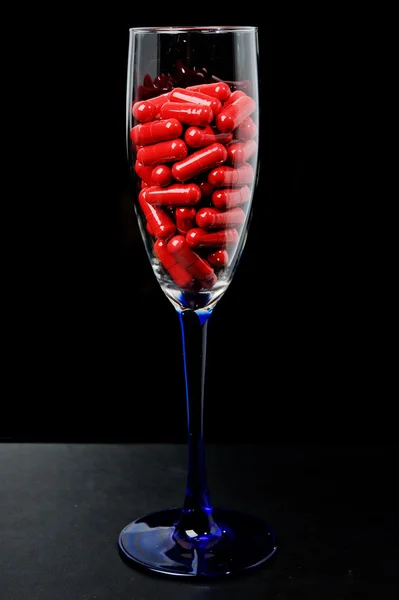 Red capsule in a glass dish — Stock Photo, Image