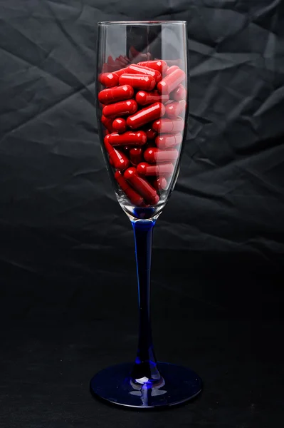 Red capsule in a glass dish — Stock Photo, Image
