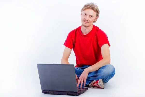Mann arbeitet am Boden mit Laptop — Stockfoto