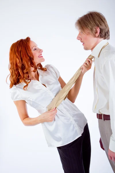 Young woman pulling man by tie — Stock Photo, Image
