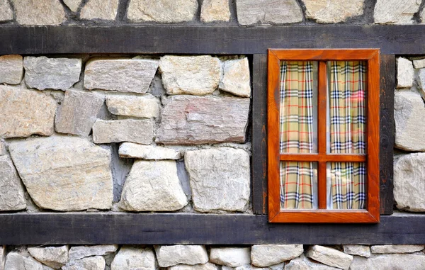 Wall of an old stone house with a window — Stock Photo, Image